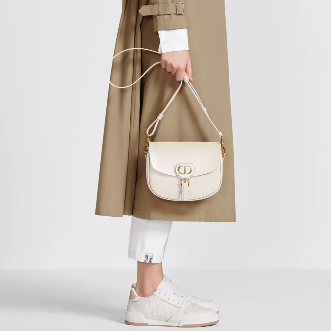Afrundet crossbody-taske i elfenbensfarvet læder med klap til kvinder